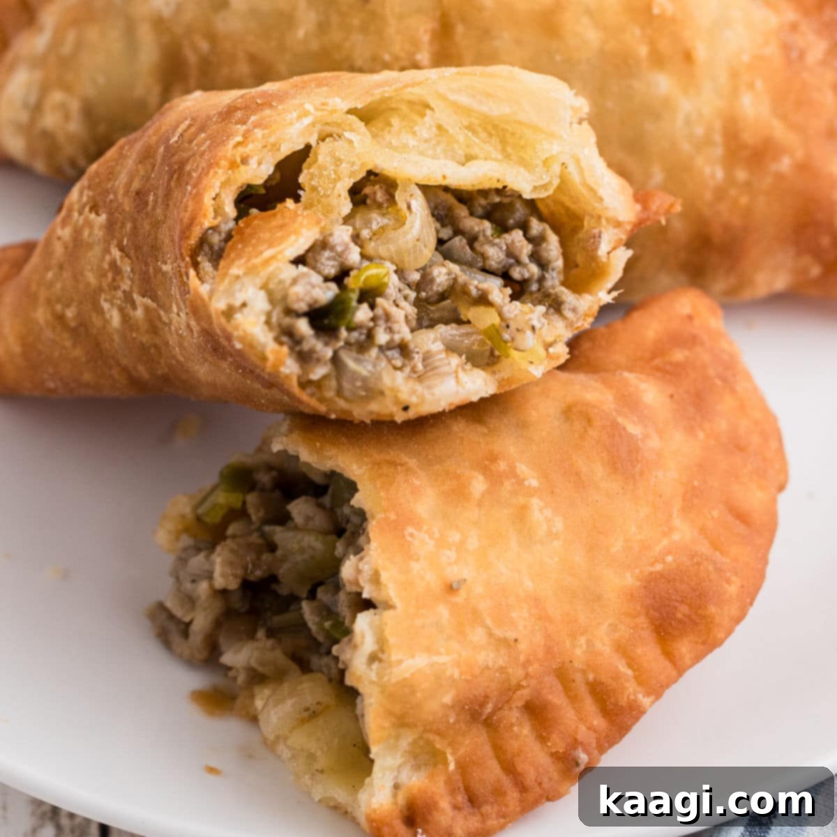 A Natchitoches Meat Pie, sliced in half to reveal its savory, seasoned meat filling.