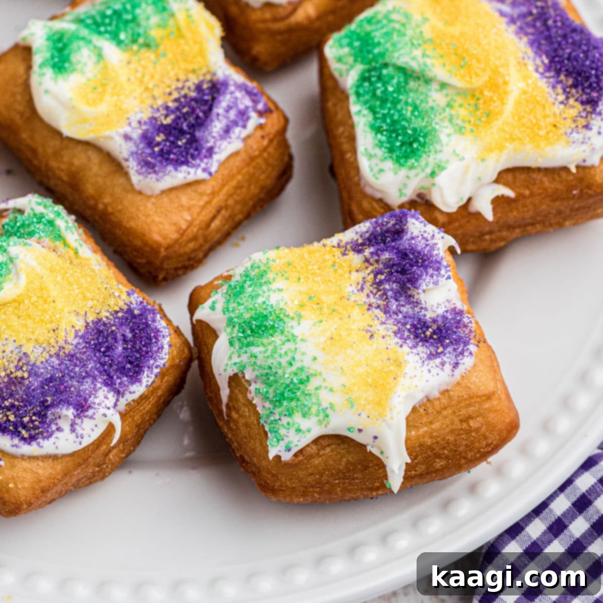 A close-up shot of golden-brown Mardi Gras Beignets, generously dusted with powdered sugar.