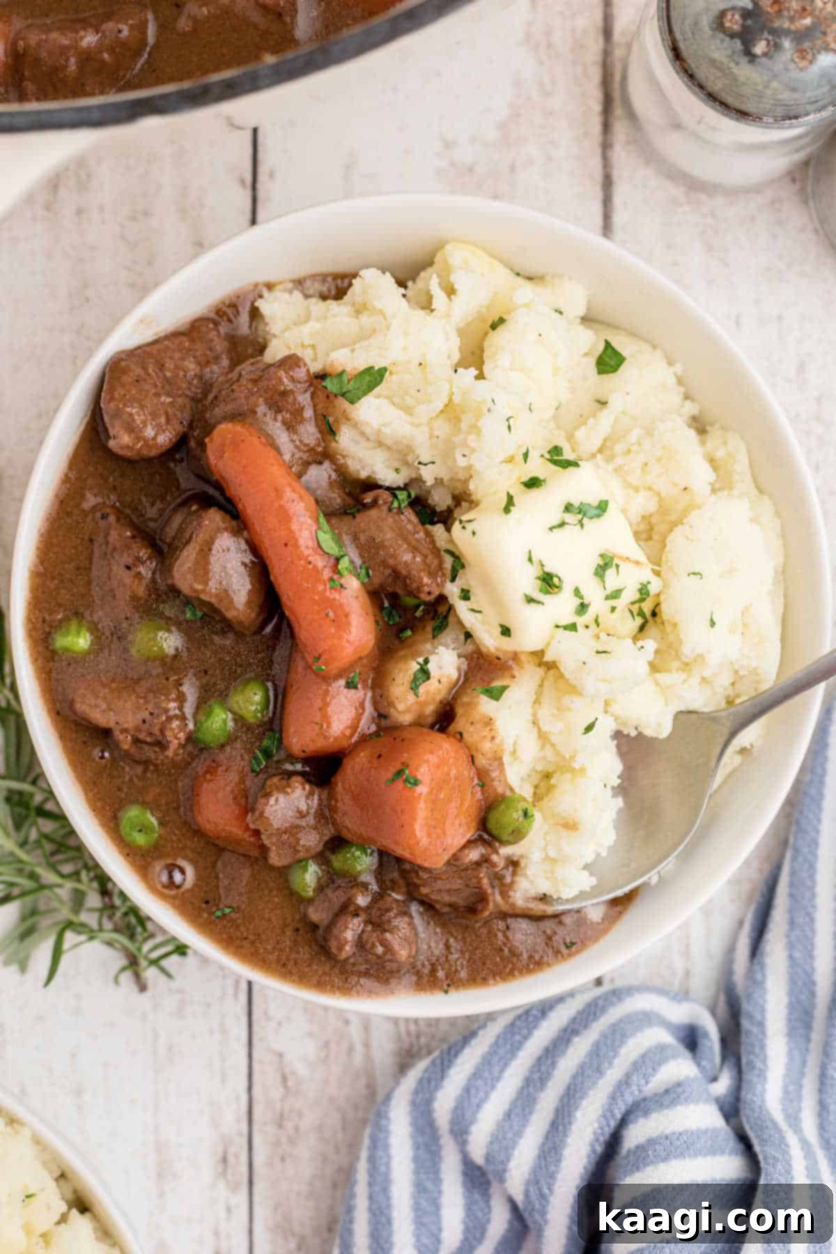 Overhead view of a bowl of Irish Stew with Mashed Potatoes with a spoon digging in.